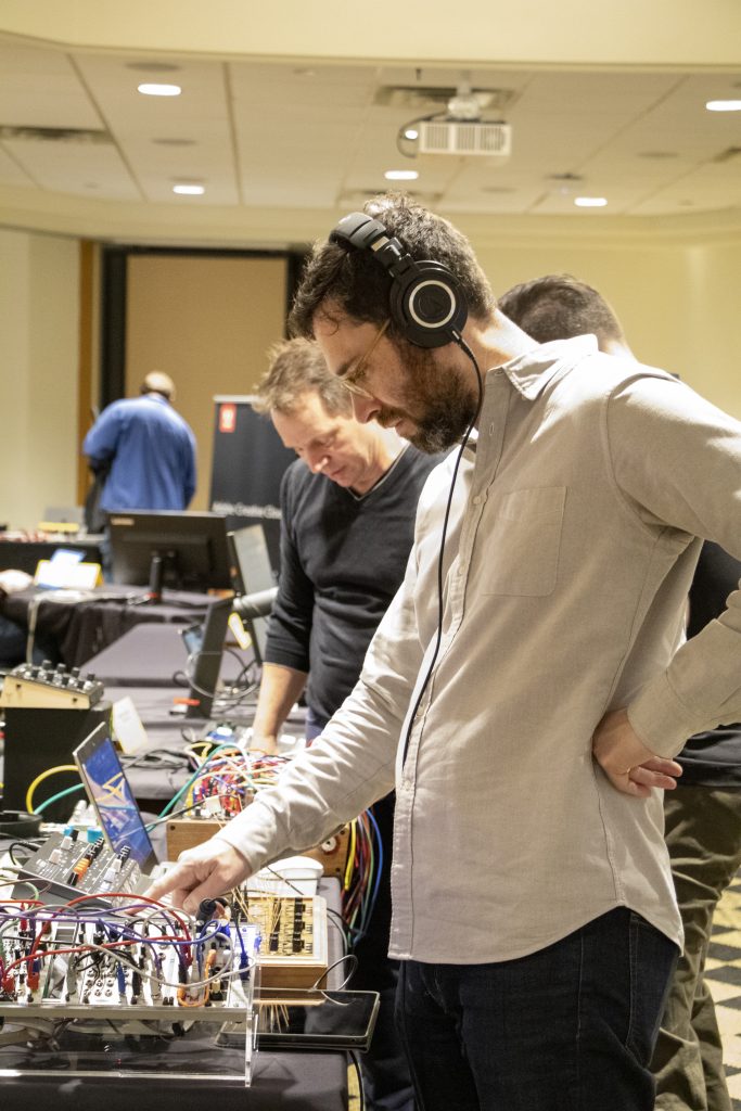 TechX attendee experiments with audio equipment at a TechX table