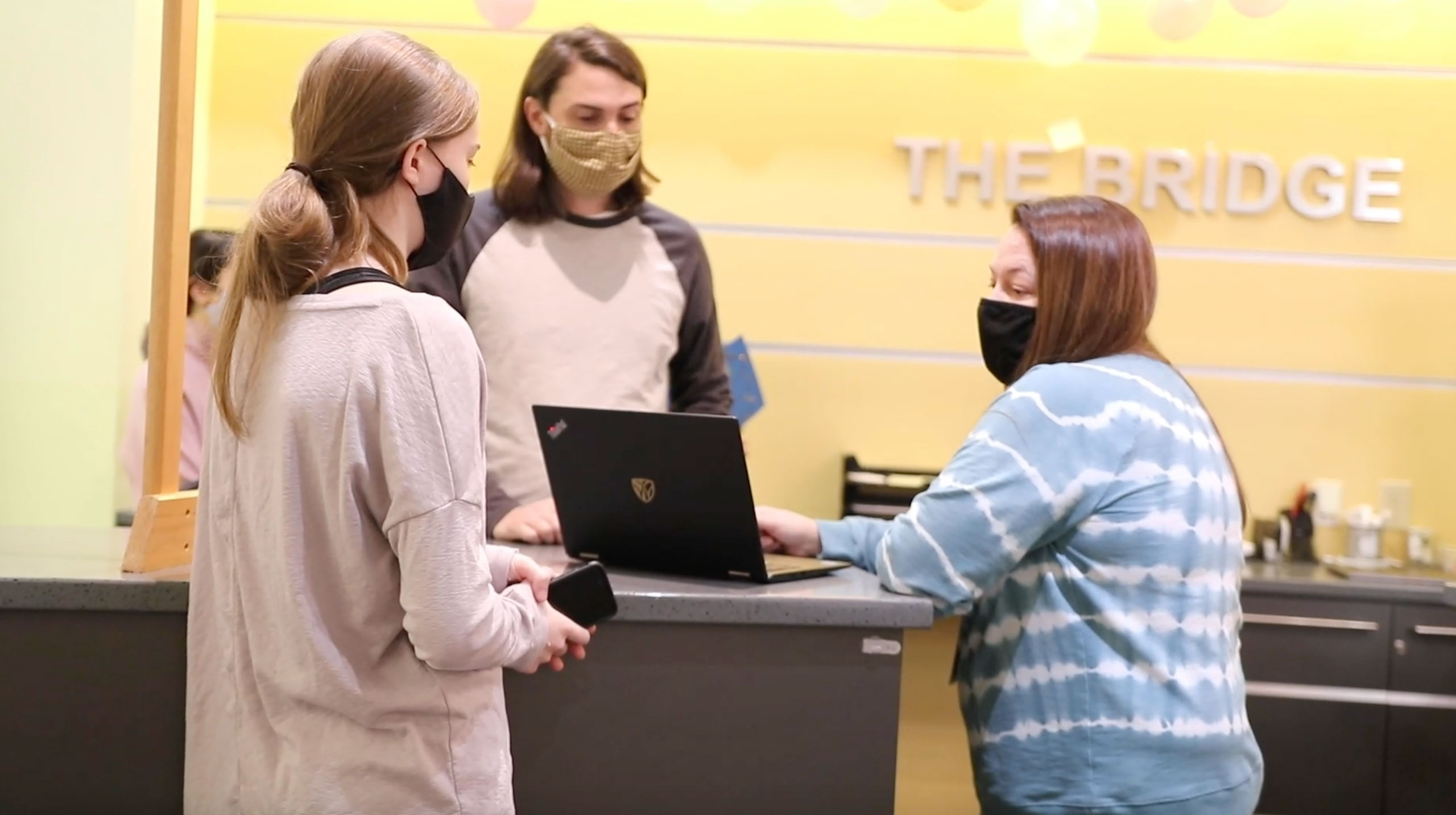 Help Desk representatives assisting a student with her laptop