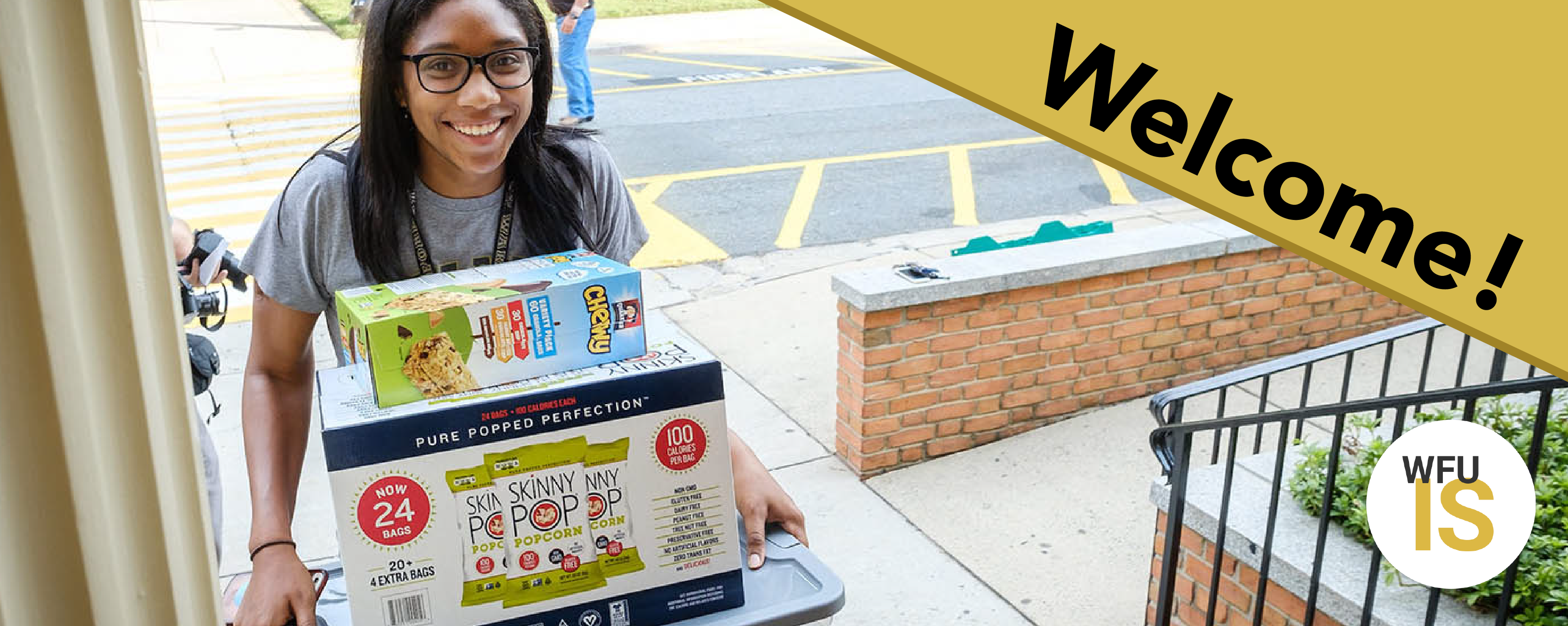 Student carrying items as she moves into a residence hall