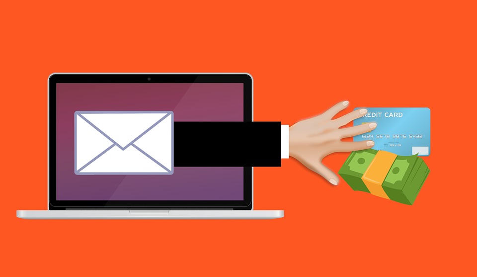 hand reaching out of computer for money and a credit card indicating a phishing scam